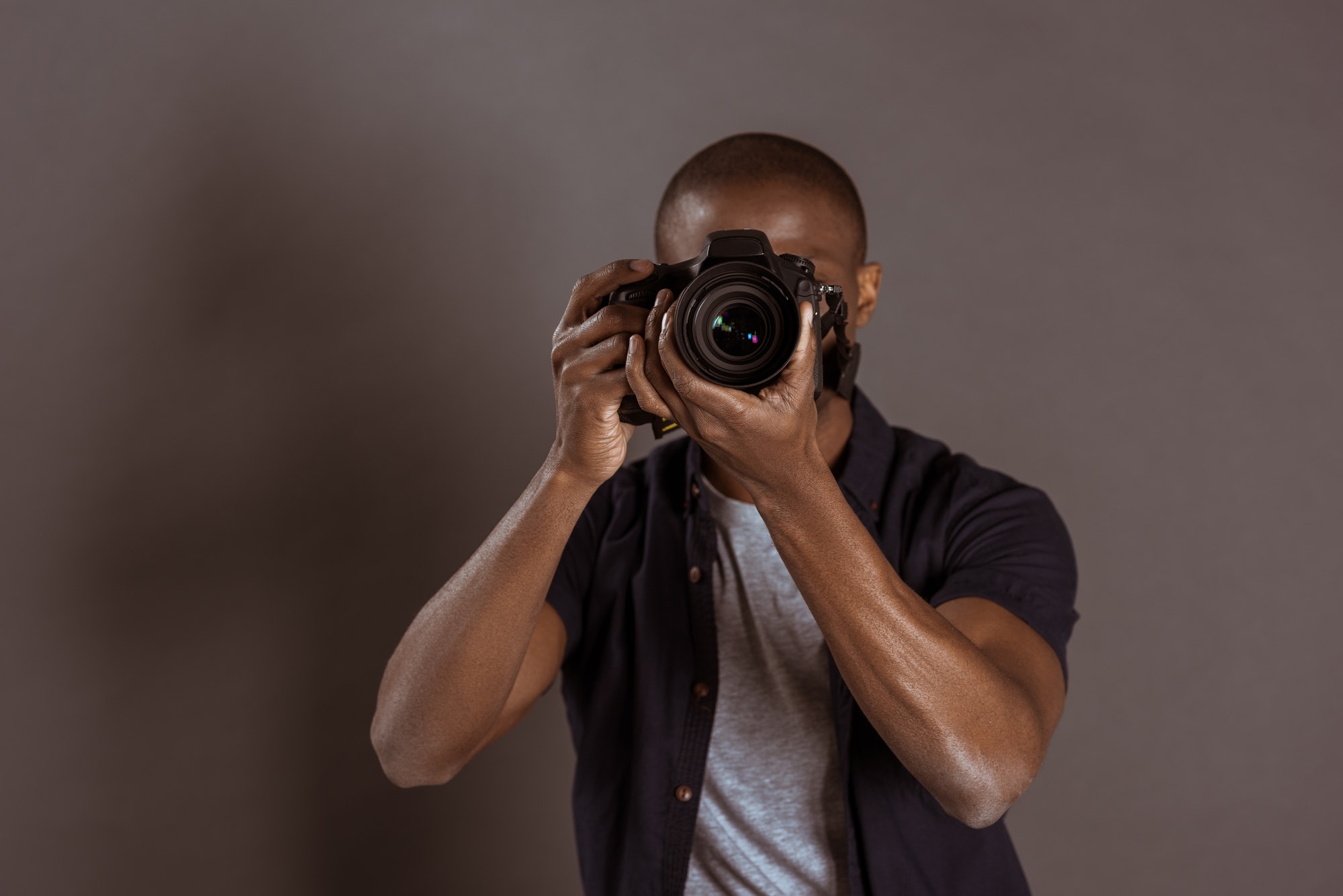 obscured view of african american photographer taking picture on photo camera