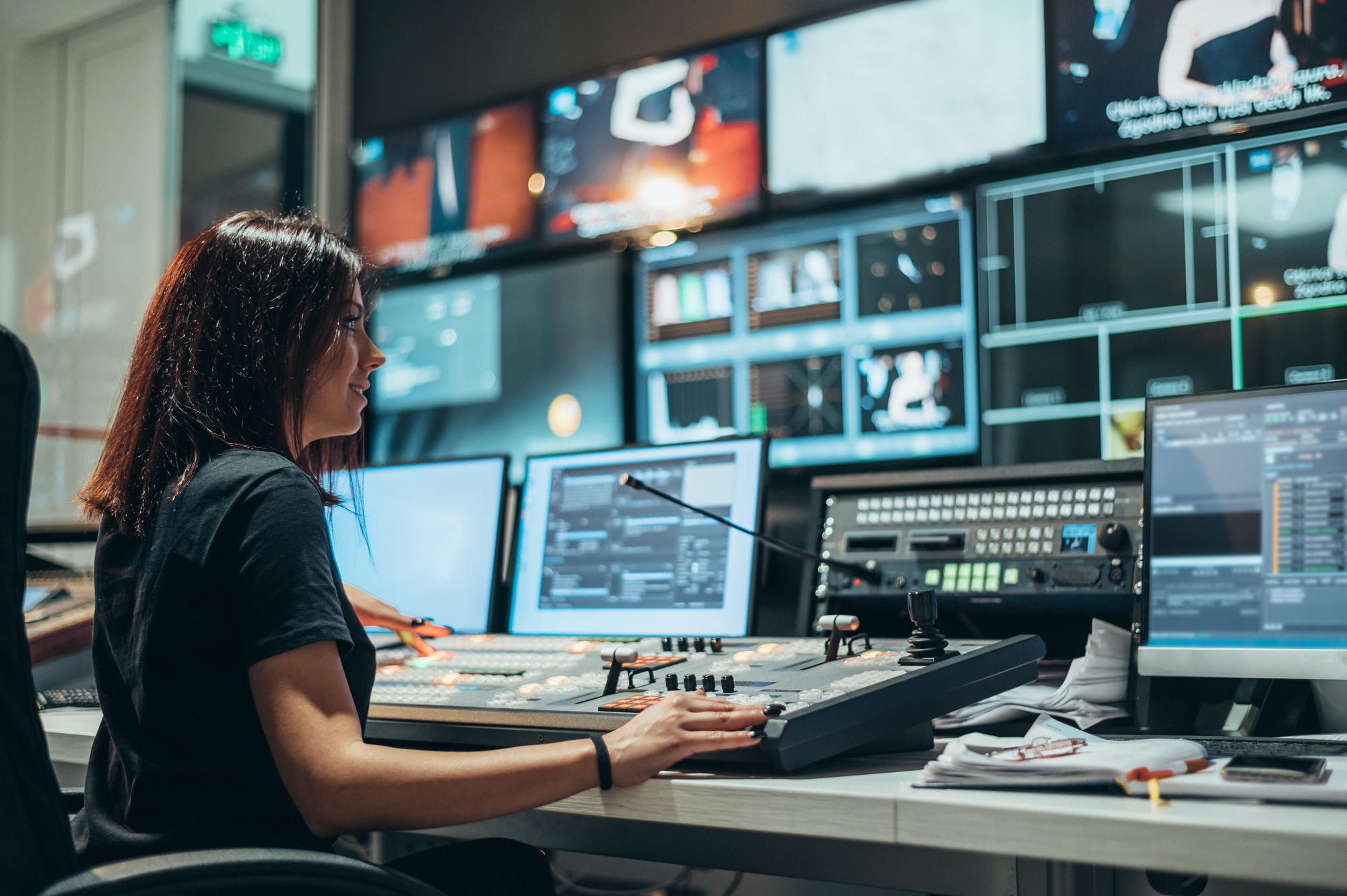 Young beautiful woman working in a broadcast control room on a tv station
